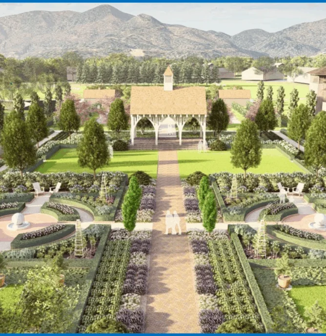 Aerial view of a formal garden with symmetrical hedges, pathways, a gazebo, statues, benches, and mountains in the background.