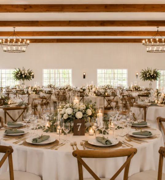 Elegant wedding reception hall with round tables, floral centerpieces, candles, and chandeliers—perfect for events near hotels in downtown Dillard House PA.